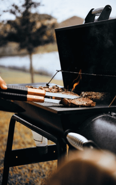 Stor grill med flammer og kød